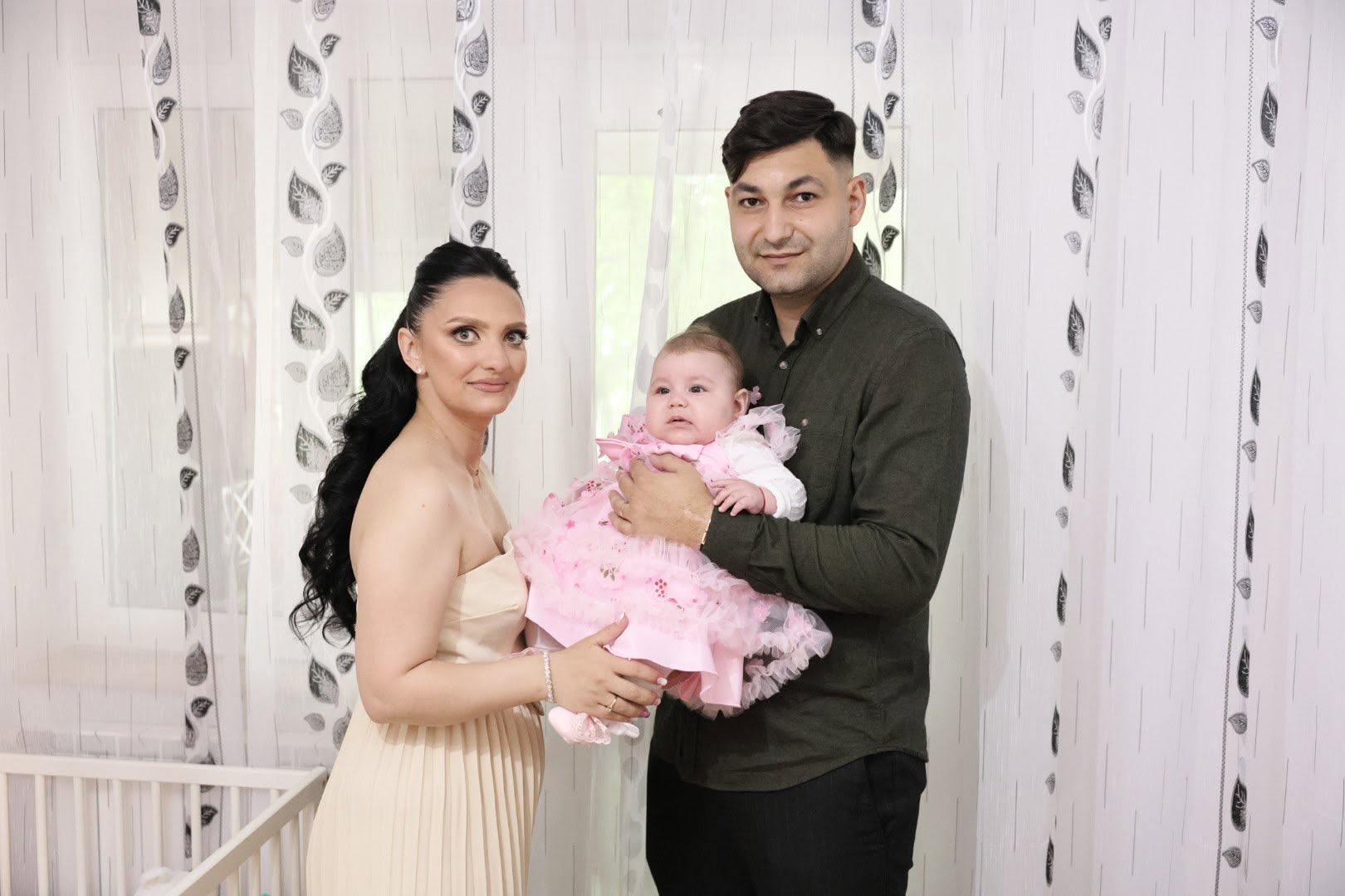 Familie cu fetița în rochiță roz la botez